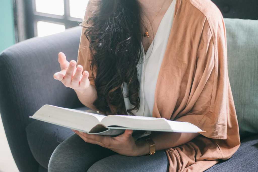 Repeat outloud what you've learned - woman vocalizing over a textbook