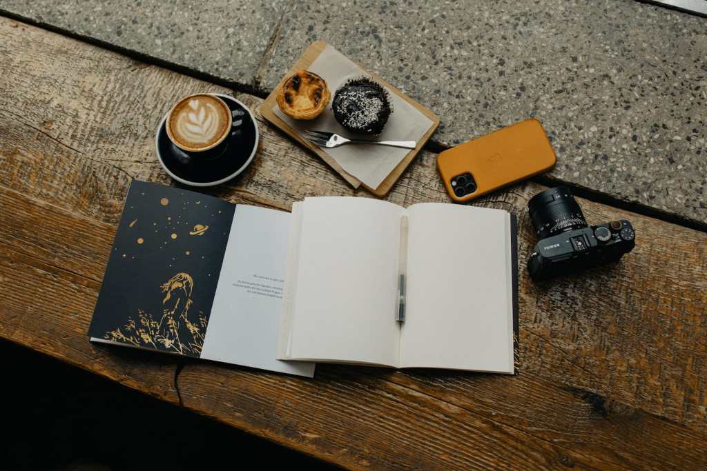 productive creative workspace with coffee and muffins with phone face-down